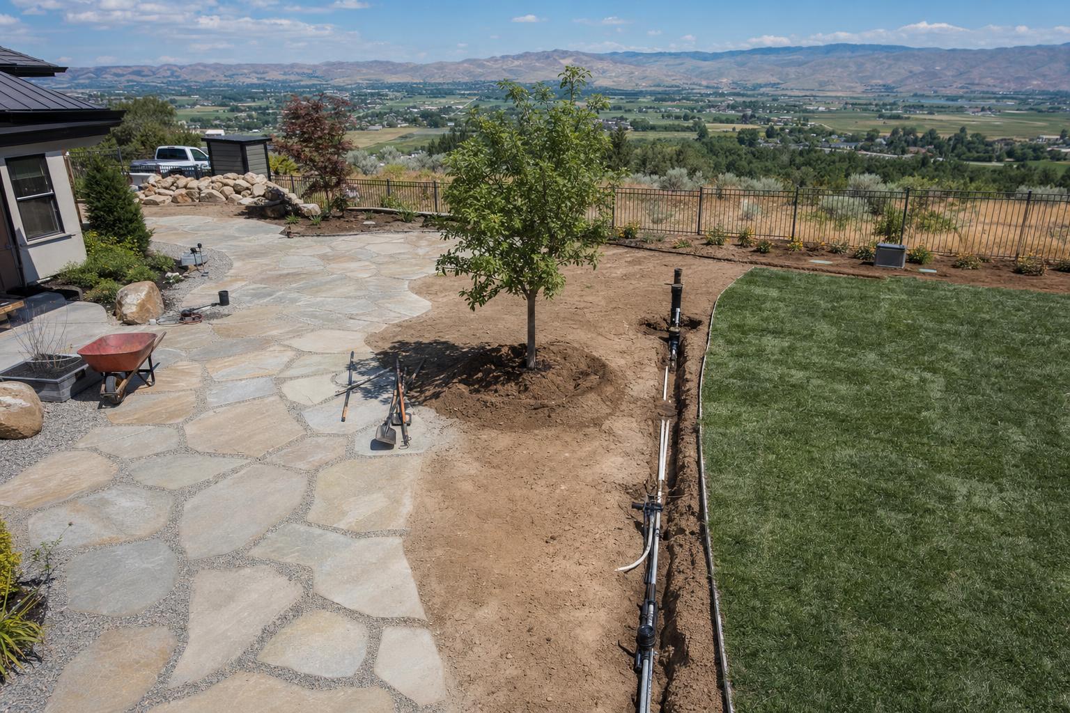 Treasure Valley landscaping project with flagstone patio, young shade tree, sprinkler system, and freshly laid sod showing the materials and scope of a residential landscape budget